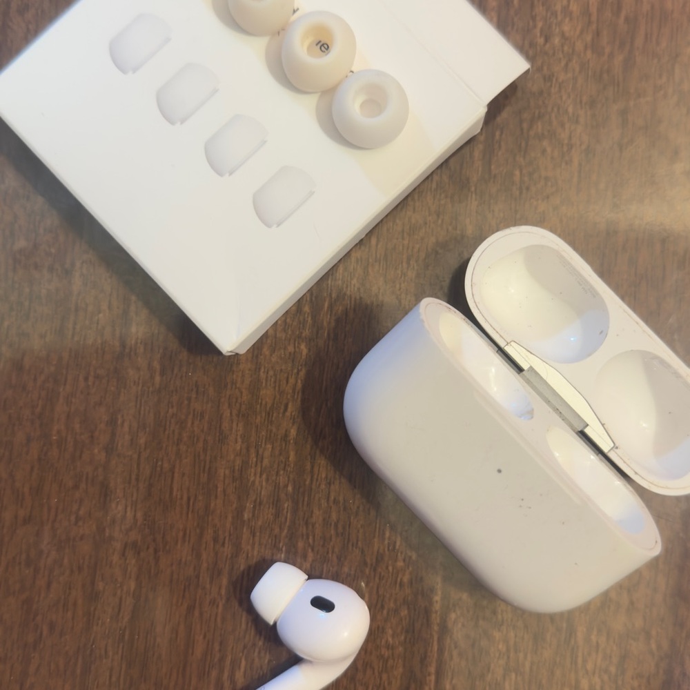 Apple AirPods Pro 2 right earbud and its charging case.